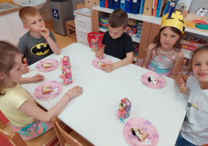 dzieci jedzą tort i pija soczki